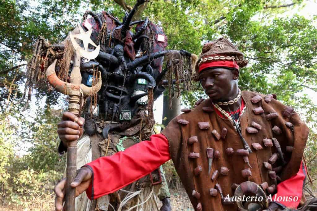 mask of dozo hunters and man with gri-gri