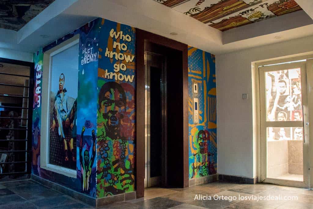 vestíbulo y ascensor del kalakuta museum con imágenes de fela kuti en muchos colores